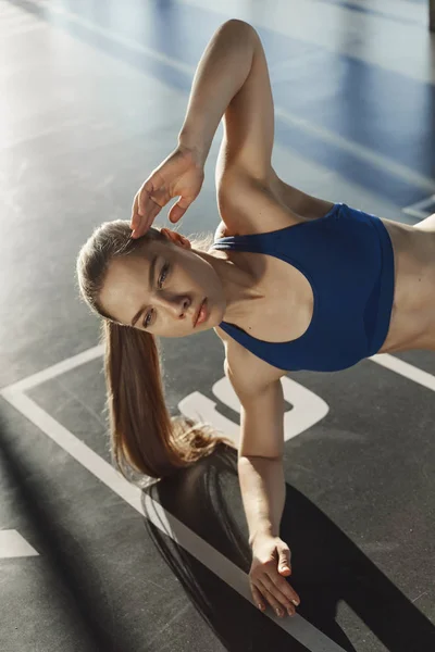 사각 사각 press-ups 연습을 만드는 언론 근육 토닝 activewear 스포츠 브래지어 훈련 팔 뚝 서 층 체육관에 한 손으로 판자에에서 결정된 집중된 sportswoman의 수직 샷 — 스톡 사진