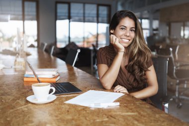 Charming İspanyolca öğretmen ortak çalışma kentsel alan beklemek öğrenci smilign mutlu laptop kağıtları yakın oturup çalışma sayfası hazırlamak, araştırma projesi yazma kamera mutlu cappuccino içme