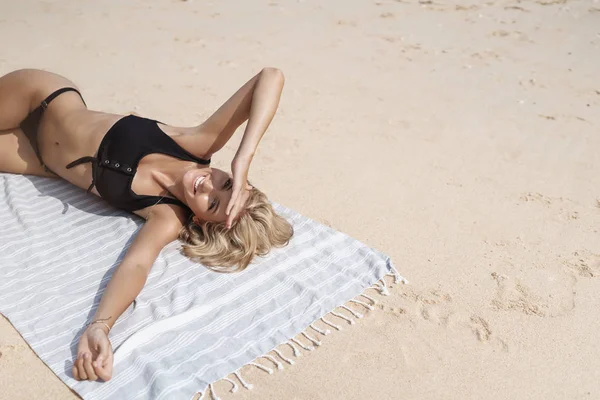 トップビュー気楽な幸せな女性観光客のブロンドの髪はビキニを着用して砂浜毛布を着用日光日焼けは、影の手の額の外観カメラは楽しんで楽しい夏休みを楽しむ、レクリエーションリゾート — ストック写真