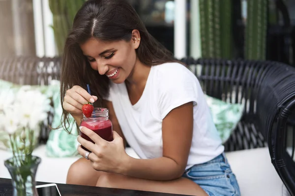 Bergembira riang lucu perempuan eropa cokelat cokelat kecokelatan tertawa genit memerah bersenang-senang baik ramah perusahaan duduk kafe luar sofa teras kopi meja minum stroberi smoothie — Stok Foto