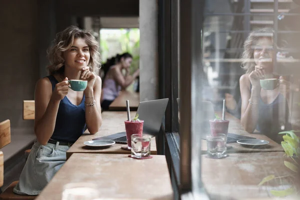 Dreamy bahagia gadis muda memikat duduk kafe kopi minum cappuccino, smoothie menatap melalui jendela orang yang lewat berpikir menciptakan proyek freelance bekerja, nomad digital menggunakan laptop — Stok Foto