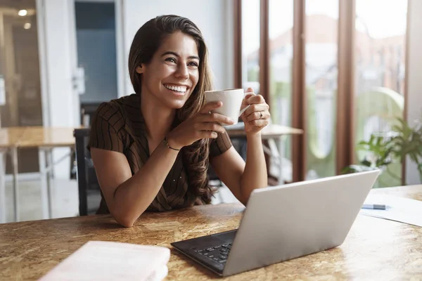 El trabajo va rápido buen equipo alrededor. Encantadora mujer de negocios sin preocupaciones llevan a cabo taza de café riendo mirando compañero de trabajo sonriendo bromas portátil de trabajo estudiando documentos, tomar breat disfrutar de té taza agradable — Foto de Stock