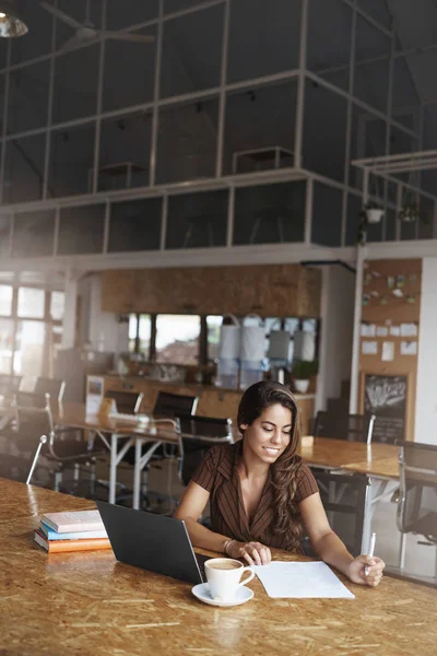 Vertical shot successful lucky businesswoman liking run business prepare papers researching reading important documentation smiling satisfied good company results sit near laptop drink coffee Stock Picture