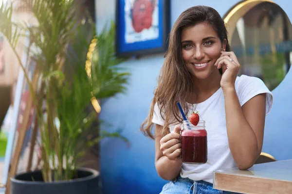 Memikat lucu genit gadis muda berambut cokelat kecokelatan, menyentuh pipi gembira tersenyum terus strawberry goyang smoothie mendengarkan menarik cerita terlihat coquettish memiliki kencan romantis kafe jalan teras — Stok Foto