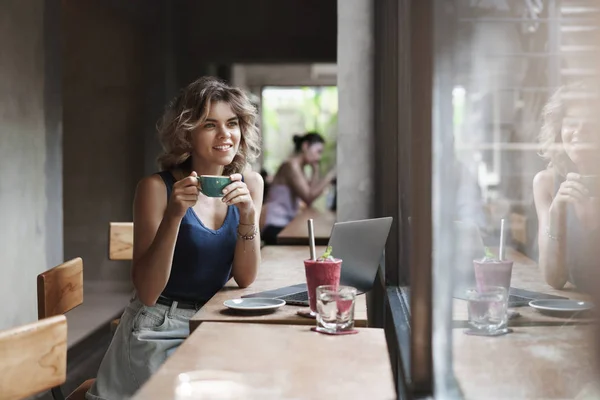 มีเสน่ห์สาวผมบลอนด์ฝันดิจิตอล nomad นั่งดื่มกาแฟคาเฟ่พื้นที่ทํางานร่วมกันในเมืองมองออกไปนอกหน้าต่างยิ้มฝันเพลิดเพลินกับการแบ่งโครงการทํางานอิสระ แนวคิดเศรษฐกิจ — ภาพถ่ายสต็อก