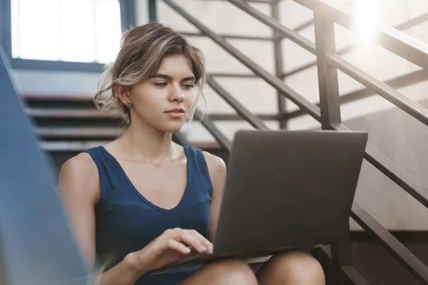 Fókuszált tetszetős szőke fiatal 20-as évek szabadúszó női dolgozó új projekt egyedül a szabadban ülni lépcsőn tartsa laptop térdét meg meghatározott nettó könyv készülék képernyőjén keyboarding, tanul, mielőtt döntők — Stock Fotó