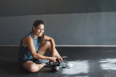 Sağlık, motivasyon ve spor salonu konsepti. Sporcu fitness antrenörü bakım kasları almak, crossfit squats sonra dinlenme, kettlebell tutun, sağlık kulübü zemin oturup, gülümseme kamera memnun, egzersiz sonrası terli