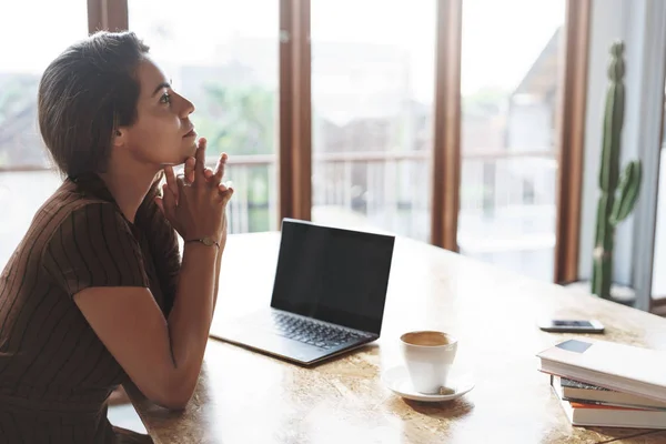 Aantrekkelijke gelukkige succesvolle zakenvrouw luisteren werknemers rapporten zitten tevreden tevreden in de buurt van venster, laptop geopend drinken koffie houden handen boven kin attent, denken maken beslissing — Stockfoto