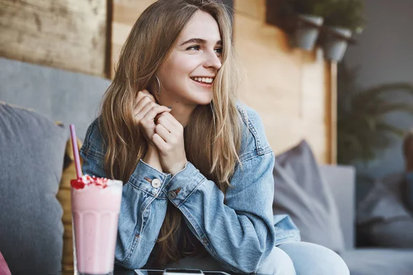 Mahasiswa perempuan Trendytalkative di jaket denim suka membeli gadget, menggunakan tablet digital dan smartphone selama waktu luang, minum milkshake dan menatap samping pantai sambil duduk di kafe — Stok Foto