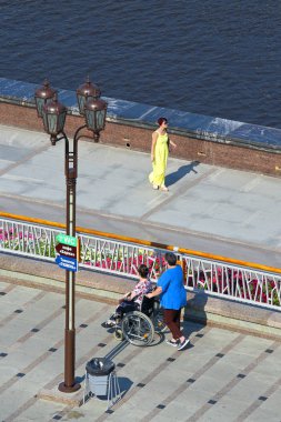 Tyumen, Rusya Federasyonu-Ağustos 14, 2018: Güzel elbiseli Bayan geliyor bir tekerlekli sandalyede geziniyor kadınlarla tanışmak için