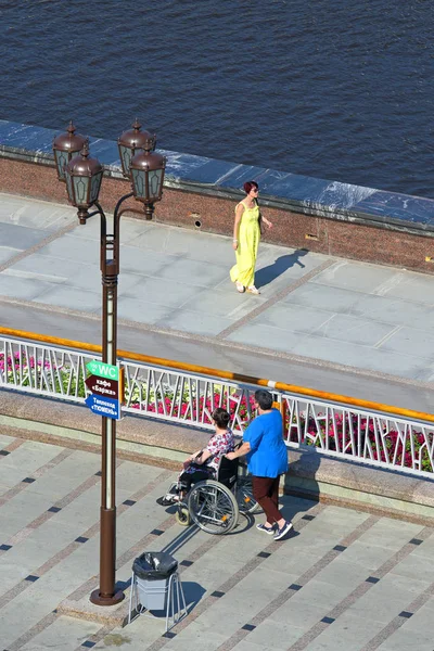 Tyumen, Rusya Federasyonu-Ağustos 14, 2018: Güzel elbiseli Bayan geliyor bir tekerlekli sandalyede geziniyor kadınlarla tanışmak için