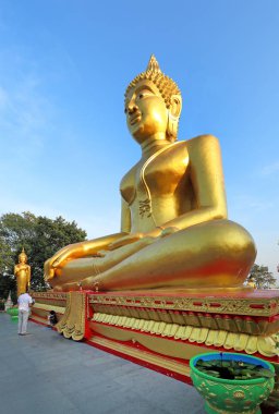 Pa mavi gökyüzüne karşı oturmuş bir Buda altın kaplama heykeli