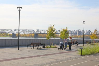 Novosibirsk, RUSSIA-20 Eylül 2020: Ob Nehri 'nin kıyısındaki sette bir bebek arabasıyla kadın yürüyüşü