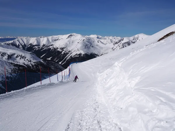 Paisagem de inverno nas montanhas e esquiador Imagens Royalty-Free