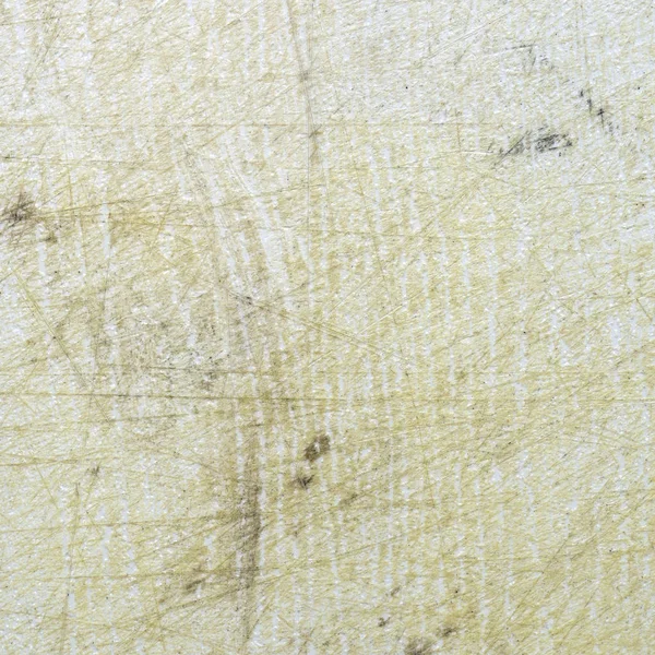 fragment of white old scratched plastic cutting board as background