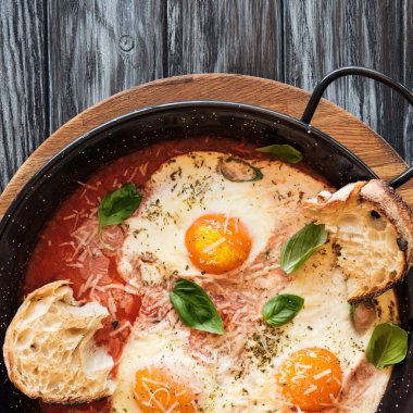 lezzetli kızarmış yumurta peynir, ekmek ve soslu tavada ile ahşap masa üzerinde görmek 