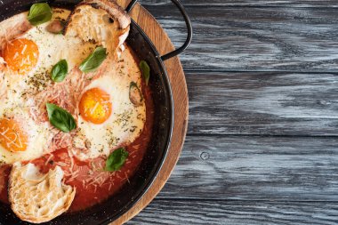 peynir, ekmek ve soslu tavada kızarmış gurme yumurta üstten görünüm ahşap tablo 