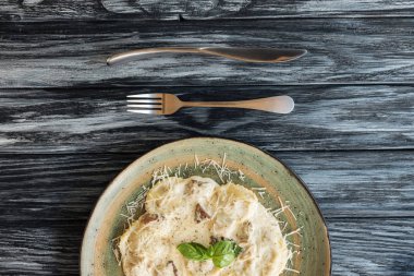 lezzetli İtalyan Mantısı peynirli üstten görünüm tabak ve çatal bıçak üzerinde ahşap masa ile 