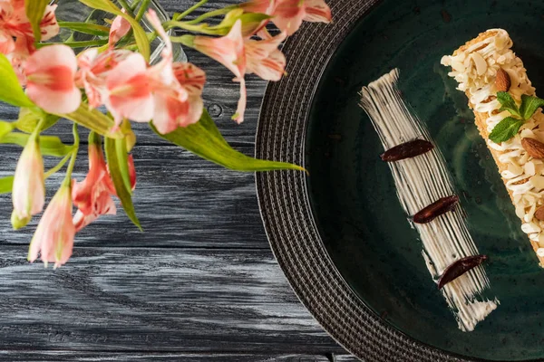 Вид Вкусный Десерт Миндалем Тарелке Цветы Деревянном Столе — стоковое фото