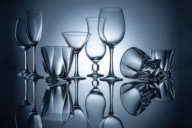 silhouettes of martini, cognac, champagne and wine empty glasses with reflections clipart