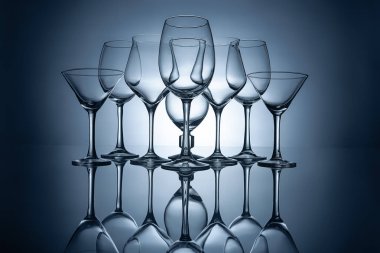 different empty wine glasses with reflections, on grey clipart
