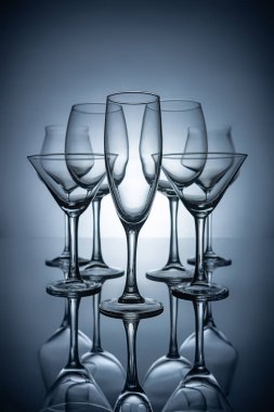 silhouettes of different empty champagne, martini and wine glasses with reflections, on grey clipart