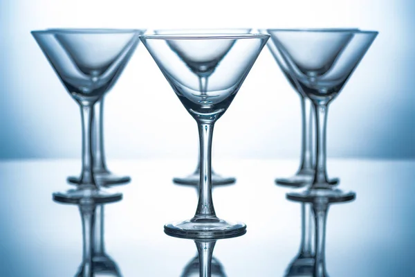 Reihe Leerer Martini Gläser Auf Grau Mit Reflexen — kostenloses Stockfoto
