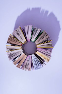 menekşe masa üzerinde daire kitap yığını üstten görünüm