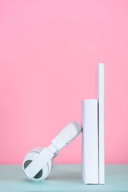 pembe tablo üzerinde beyaz Kitaplar'da eğilerek kulaklık