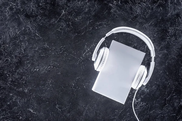 Κάτοψη Του Λευκού Βιβλίου Και Ακουστικά Γκρι Επιτραπέζια — Φωτογραφία Αρχείου