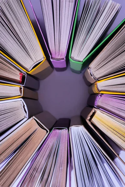 紫のテーブルに円で着色された書籍のスタックのトップ ビュー — ストック写真