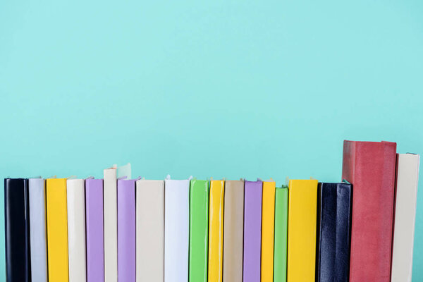 row of colored books isolated on blue