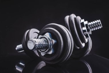 close-up view of dumbbells and reflection on black, sporting and healthy lifestyle concept