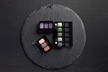 Göz gölgeler paletleri yuvarlak arduvaz arka plan üzerinde kümesi