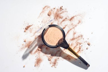 Pressed powder and makeup brush on white background with scattered foundation clipart