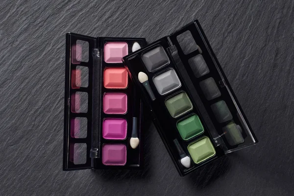 Pembe ve yeşil göz gölgeler karanlık arduvaz arka plan üzerinde