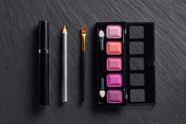 Макияж с тенями для век, карандашом и тушью на темном фоне
