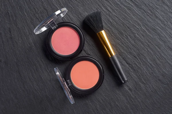 Pembe allık kümesi ve karanlık arduvaz arka plan üzerinde fırça