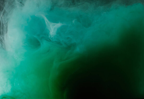 Close-up view of abstract background with green flowing ink