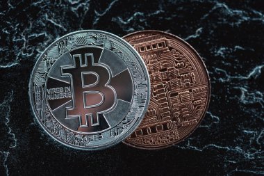Gümüş ve bronz bitcoins karanlık mermer yüzeyindeki görünümünü yakından düzenlenmiş