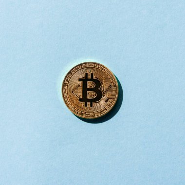 Altın bitcoin üstten görünüm mavi zemin üzerine