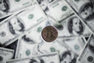 Gümüş bitcoin ve doları banknot arka plan üzerinde seçici odak