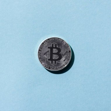 Gümüş bitcoin üstten görünüm mavi zemin üzerine