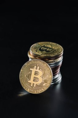 siyah arka plan üzerine çeşitli bitcoins yığını üzerine eğilerek bitcoin görünümünü kapat