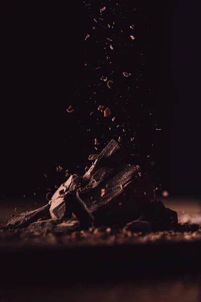 배경에 초콜릿의 조각에 떨어지는 강판된 초콜릿의 닫습니다 — 스톡 사진