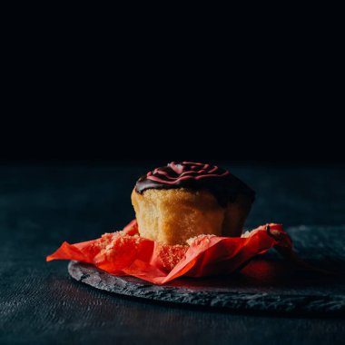 Tatlı muffin kayrak tahta üzerinde çikolata sosu ile