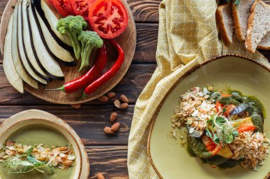 düz vejetaryen salata, krem çorbası yatıyordu ve ahşap masa etrafında taze malzemelerle düzenlenmiş