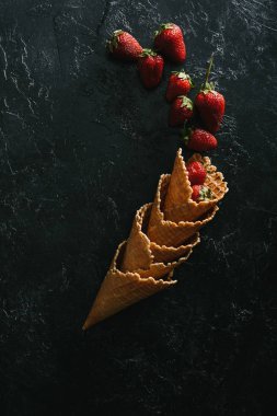 Tarafından yığın gözleme koniler koyu arka plan üzerinde kırmızı çilek