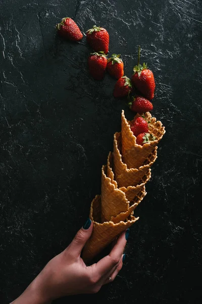 Female Hand Holding Waffle Cones Summer Strawberries Dark Background — Free Stock Photo