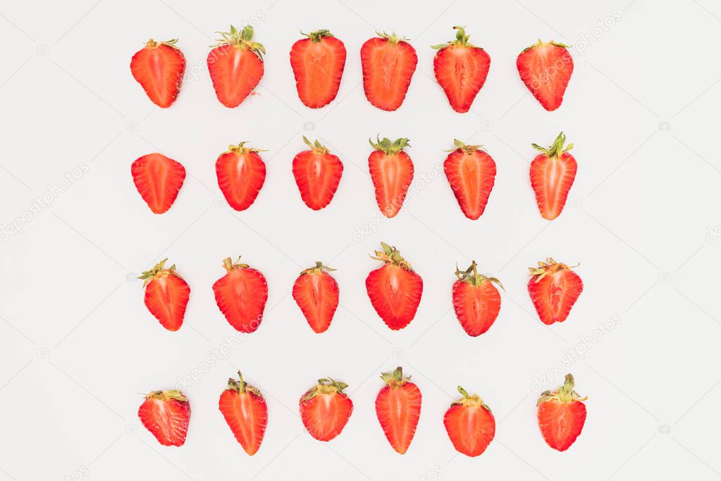Rows of cut strawberries isolated on white background